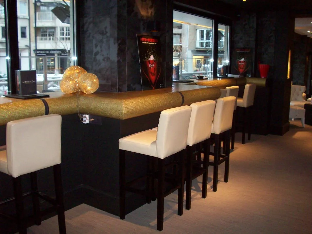 Interieur met lange bar en witte barkrukken